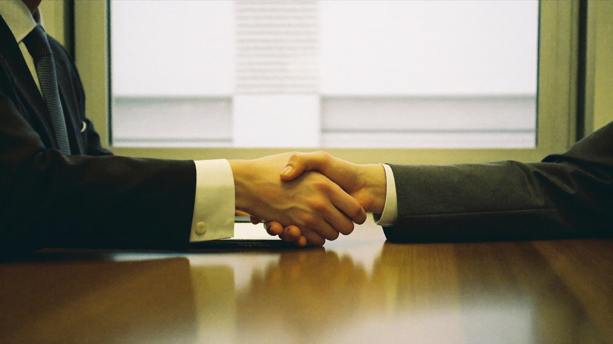 A handshake across a meeting table