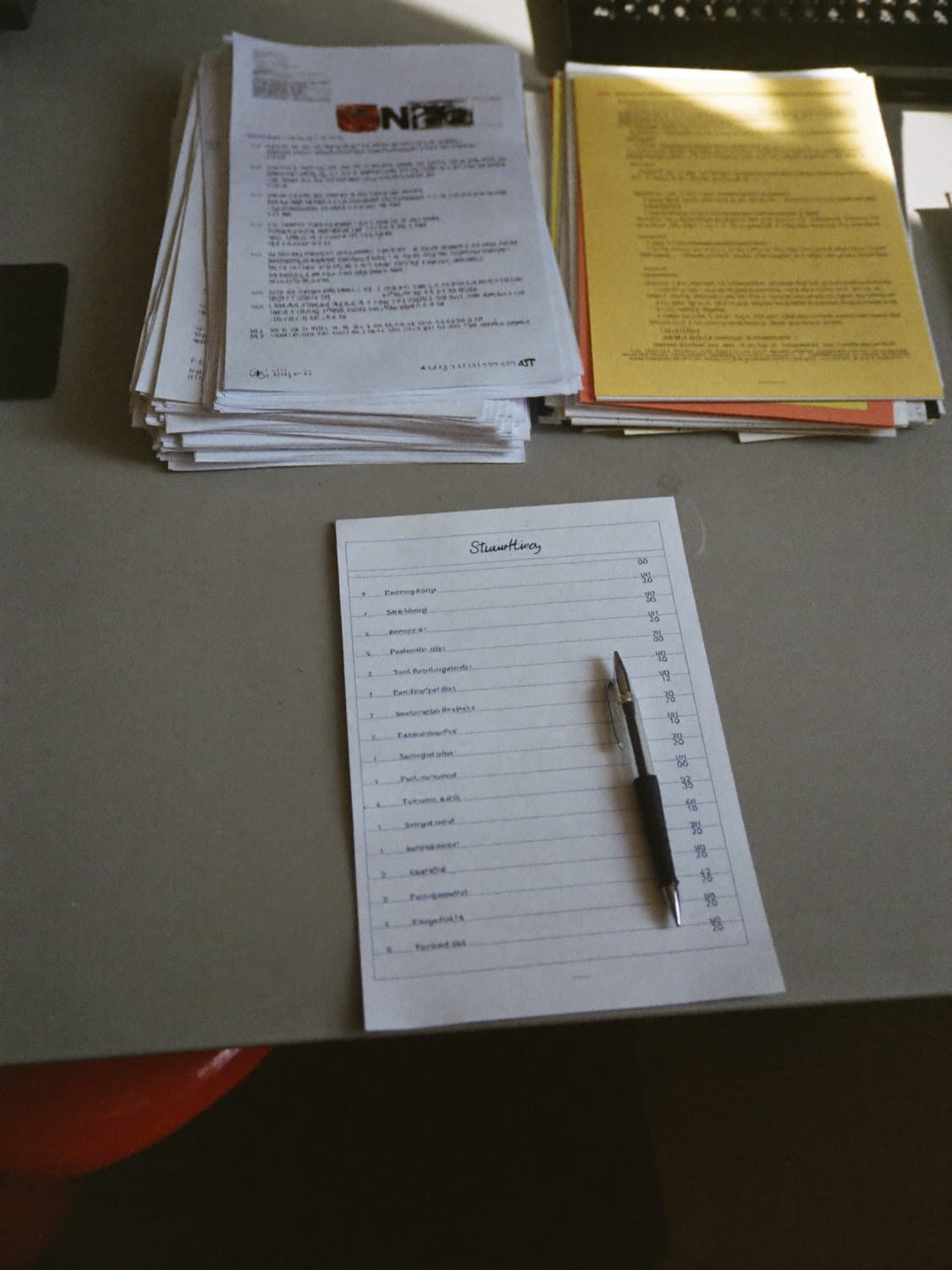 Stacks of printed applications and one short list with a pen
