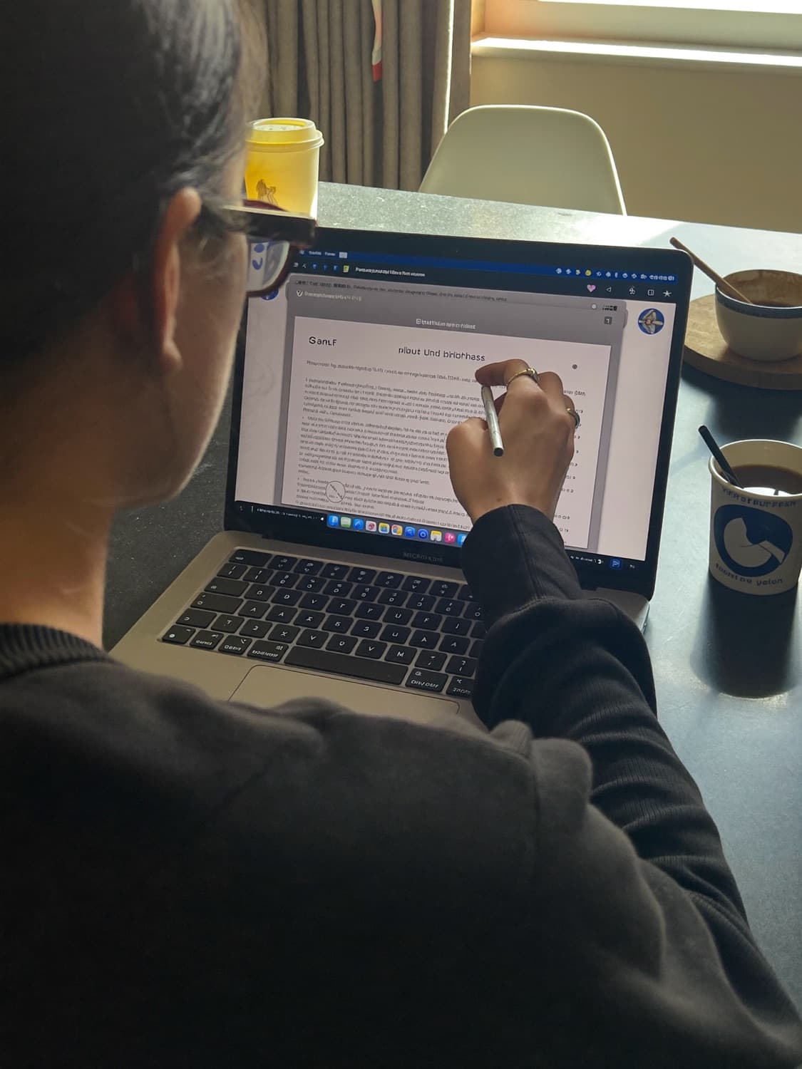 Over the shoulder of someone uploading a CV from a kitchen table