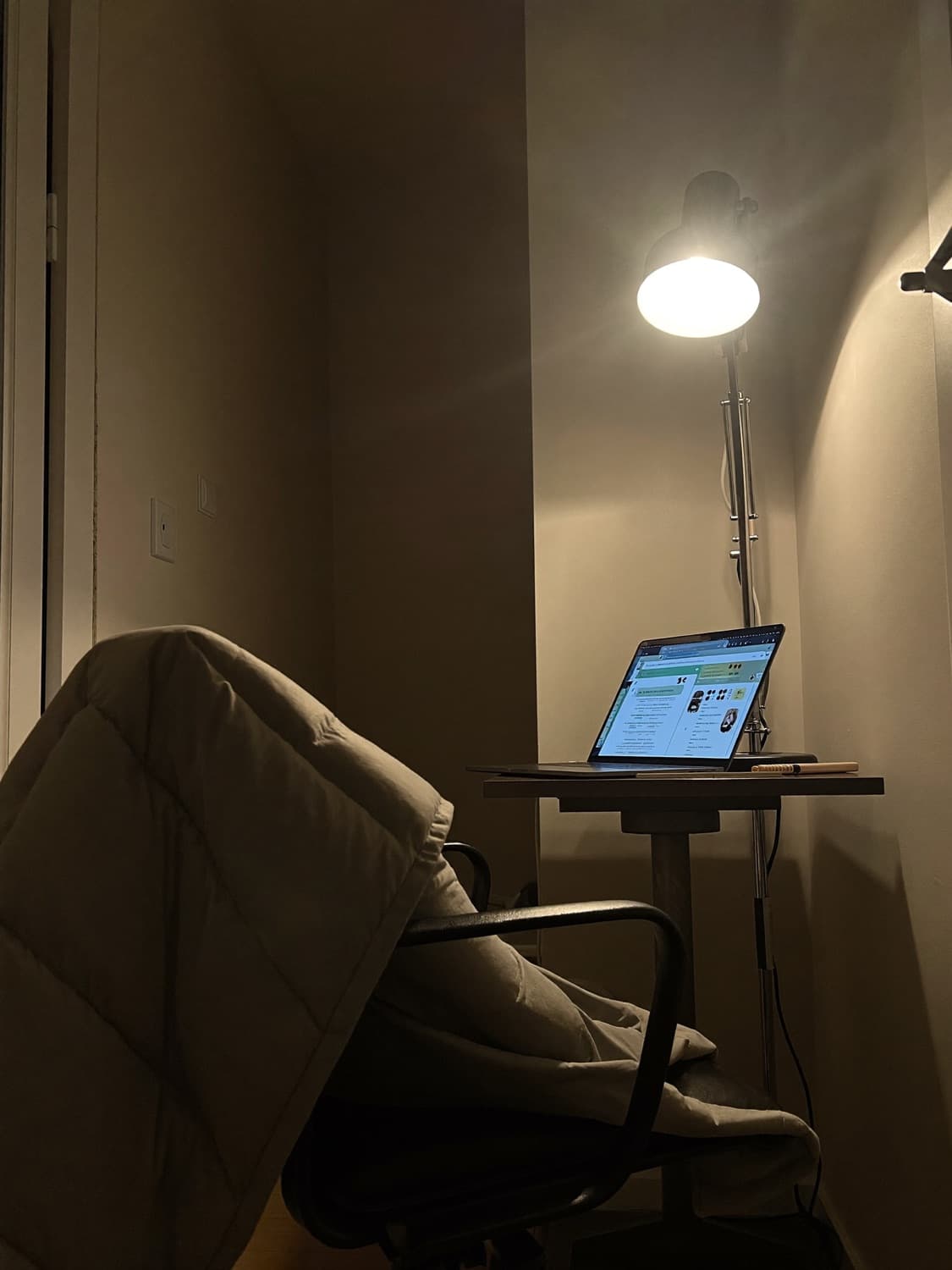 A home desk in the evening, laptop open, nobody there